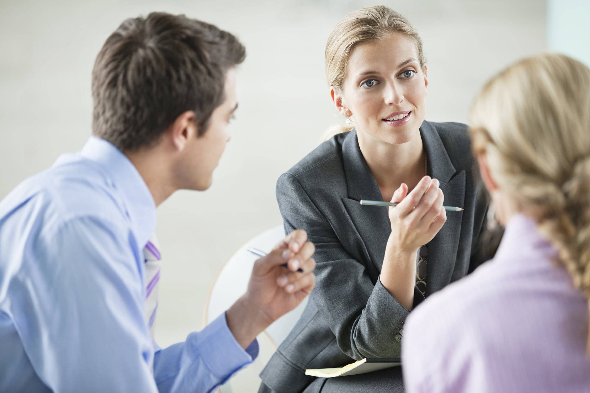 Kvinna som utför rådgivning inom management consulting, en man och en kvinna deltar i samtalet.