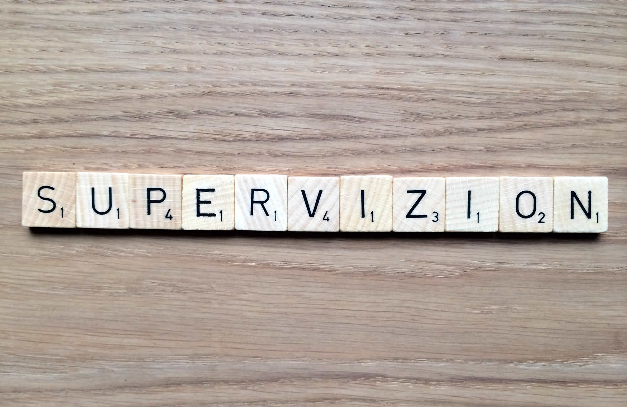 Supervizion skrivet med bokstäver på träblock